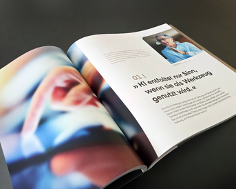 Eine aufgeschlagene Zeitschrift zeigt einen Artikel über KI, mit einem Zitat über den sinnvollen Einsatz von Werkzeugen und einem Foto einer Person.