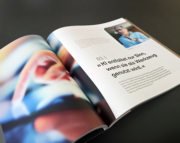 Eine aufgeschlagene Zeitschrift zeigt einen Artikel über KI, mit einem Zitat über den sinnvollen Einsatz von Werkzeugen und einem Foto einer Person.