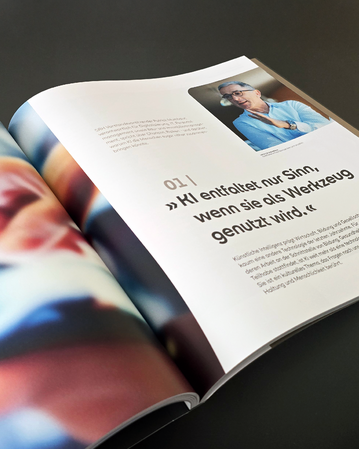 Eine aufgeschlagene Zeitschrift zeigt einen Artikel über KI, mit einem Zitat über den sinnvollen Einsatz von Werkzeugen und einem Foto einer Person.