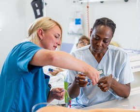 Zwei Krankenschwestern arbeiten zusammen an einem Tisch im Krankenhaus, während sie medizinische Geräte und Materialien überprüfen.